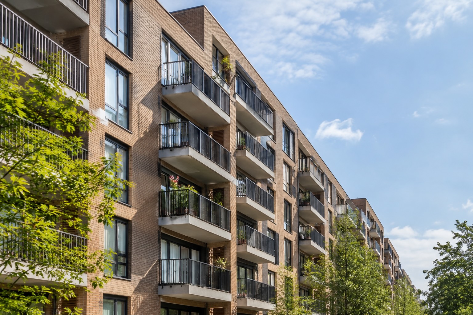 Flatgebouw van een VvE met meerdere woonlagen, gezien vanaf de straat